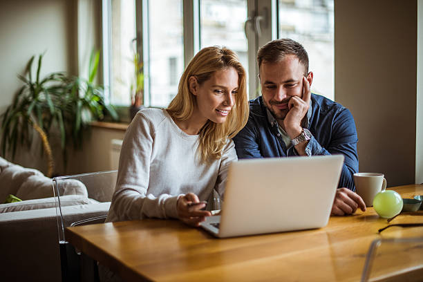 Enjoying internet time Attractive woman spending time on the internet with her husband. wife stock pictures, royalty-free photos & images