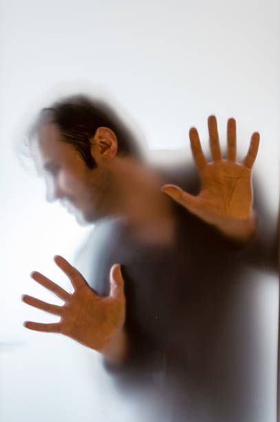 istock Shadowy man figure behind a frosted glass 622014798