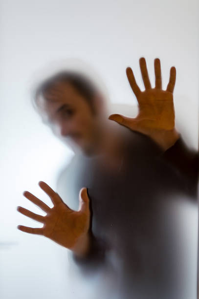 istock Shadowy man figure behind a frosted glass 622014844