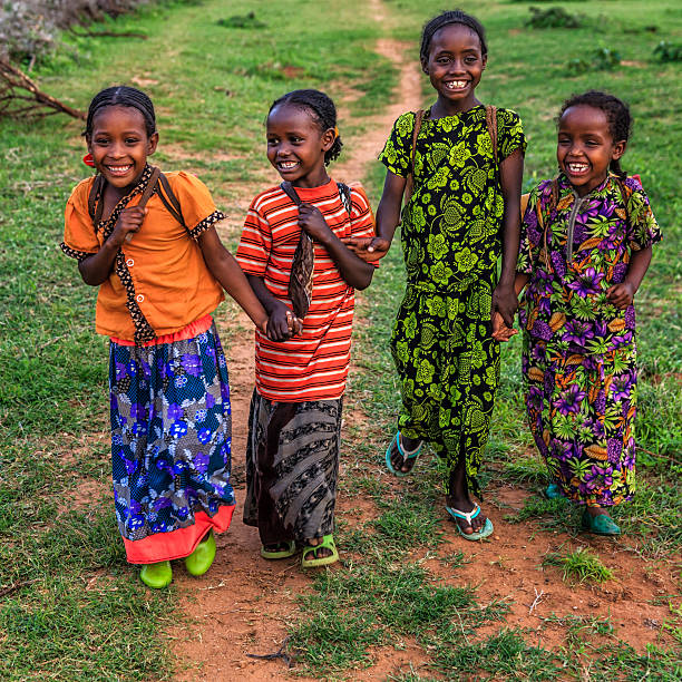 niñas africanas que llevan agua del pozo, etiopía, áfrica - village africa ethiopian culture ethiopia fotografías e imágenes de stock