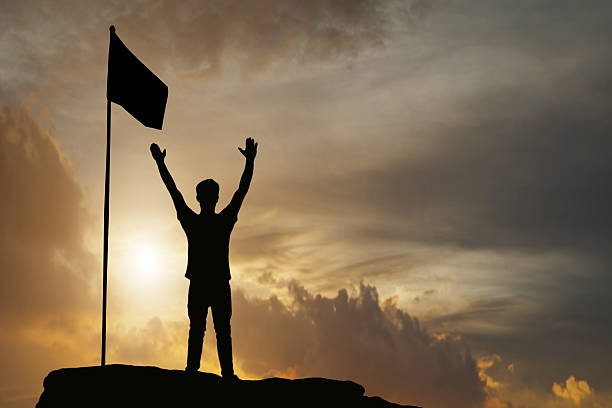 istock silhouette of man show arm up for achievements successful 622018268