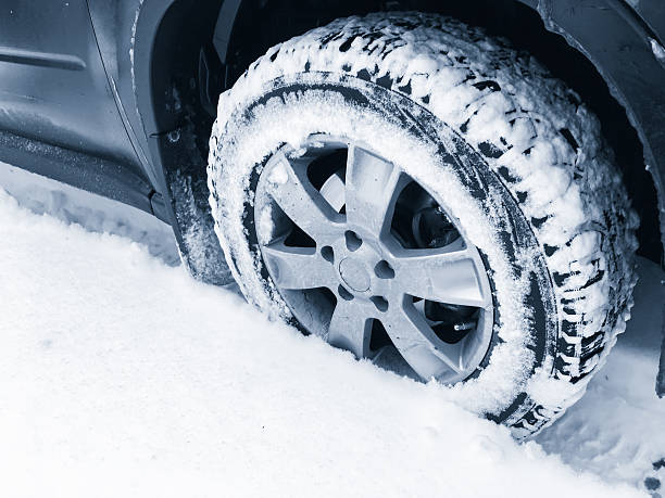 istock Car wheel with studded tire on snow 622035684