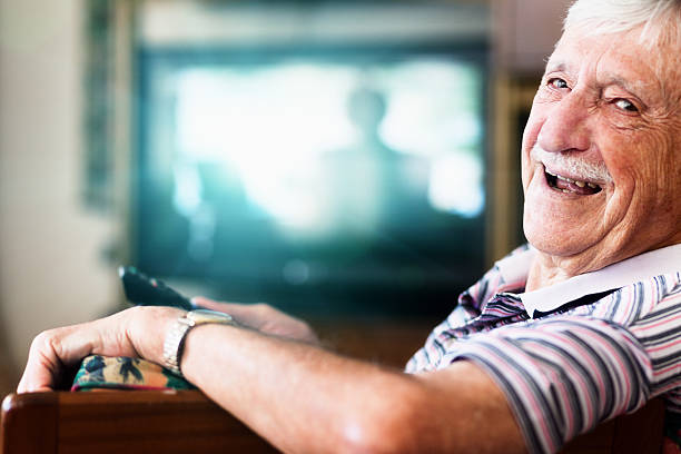 happy 90-year-old man in charge of the tv remote control - 80 year old imagens e fotografias de stock