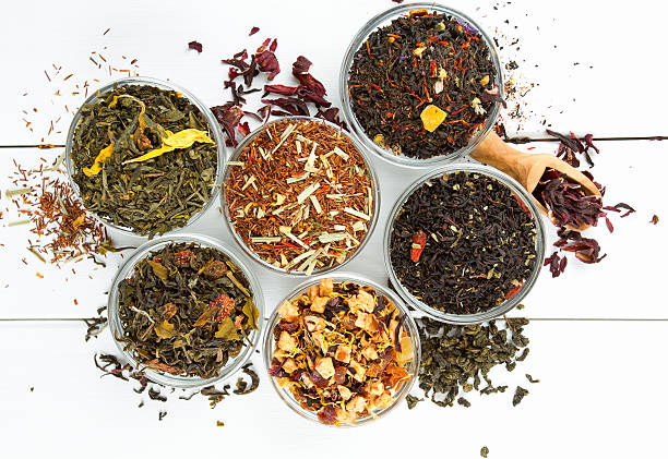 assortment of dry tea in glass bowls on wooden surface - mixed herbs imagens e fotografias de stock