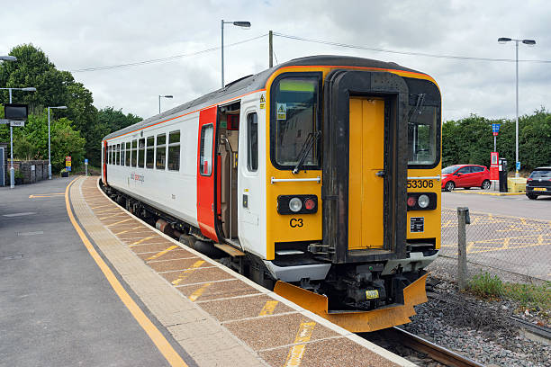 Class 153 single DMU train at Marks Tey station Marks Tey, UK - July 17th 2016: Class 153 diesel multiple unit in Abbelio Greater Anglia livery is awaiting departure for Sudbury on the Gainsborough line which is a short 11 mile branch line linking the Sudbury with the London mainline at Marks Tey. Cars are parked in the station car park to the right. clacton on sea stock pictures, royalty-free photos & images