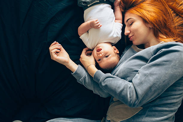 istock Happy mother with baby lying together on bed 622041846