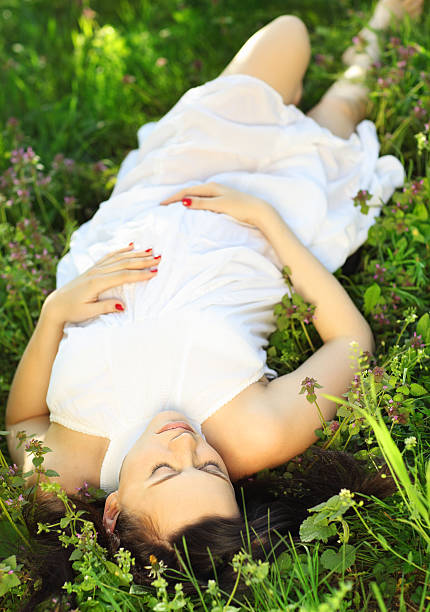 istock Beautiful pregnant woman relaxing on grass 622042036