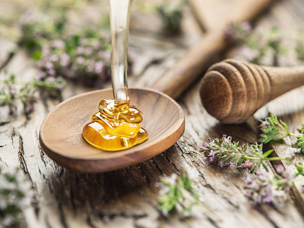 istock Herbal honey pouring into the wooden spoon. 622042914