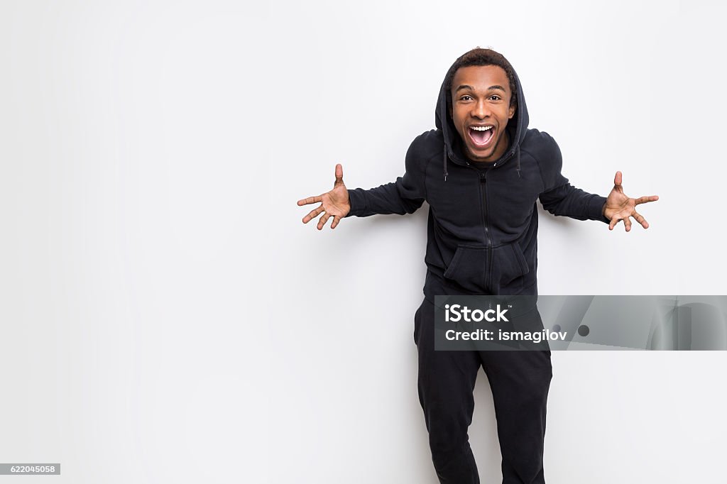 Really happy African guy Extremely happy African American man making a crazy face against white wall. Concept of a weirdo. Mock up Hooded Shirt Stock Photo