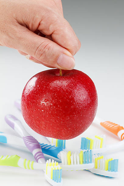 istock apple with a toothbrush, on white. dental care concepts 622045432