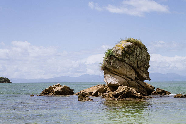 Island Rock Jetting out of the Cook Strait Photo taken in Abel Tasman National Park, New Zealand.  jetting stock pictures, royalty-free photos & images