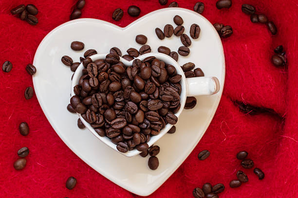 istock Heart shaped cup with coffee beans on red 622047850