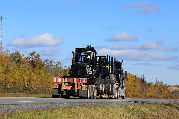 istock Semi truck with new equipment aboard trailer. 622047898
