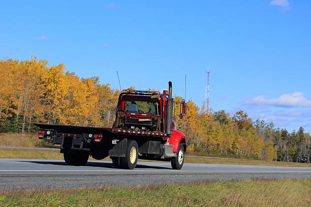istock Flat bed tow truck, trees in background. 622048078