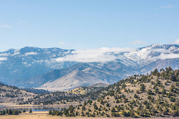 Clouds on mountains in tundra valley in northern California Clouds on top of mountains in tundra valley of Mount Shasta in northern California with pine trees on hills siskiyou lake stock pictures, royalty-free photos & images