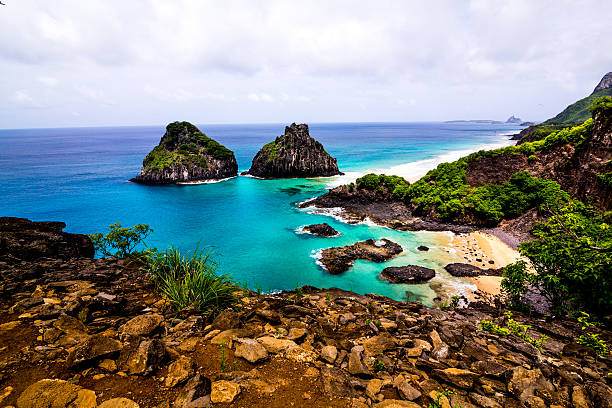 Bay of Pigs Beach in Fernando de Noronha The view of Praia dos Porcos and Ilha Dois Irmãos in the archipelago of Fernando de Noronha with its intense colors highlighted by the sun over the sea. two brothers mountain stock pictures, royalty-free photos & images
