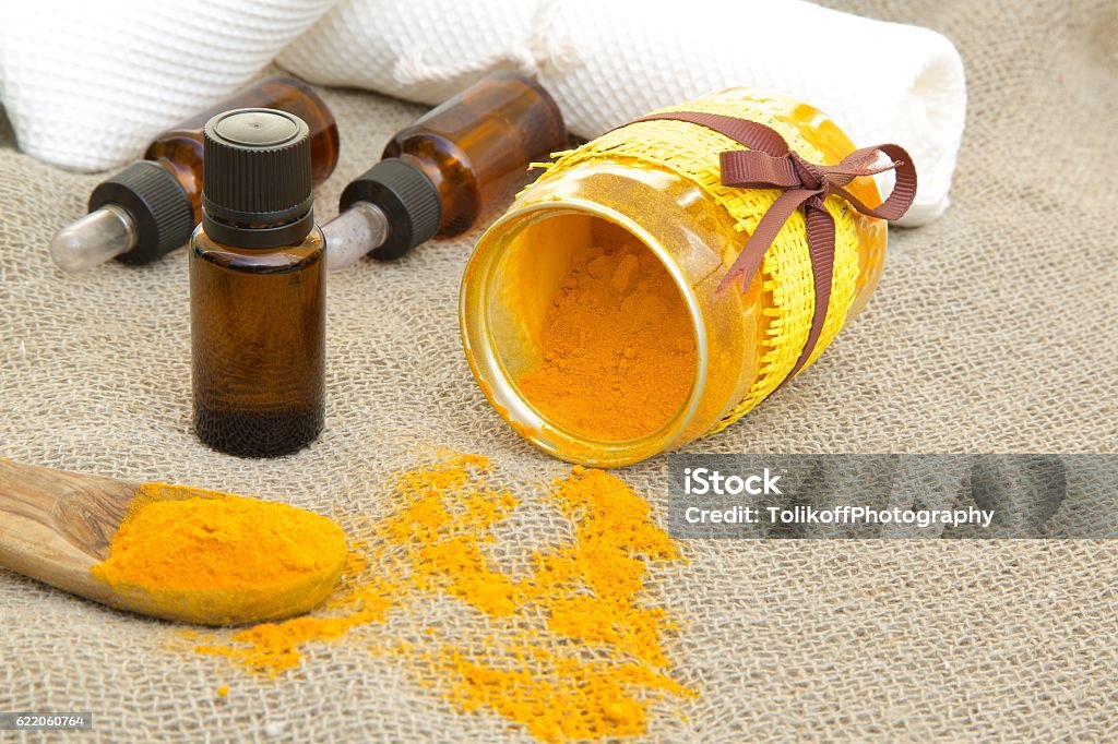 Turmeric essential oil A dropper bottle of turmeric essential oil on a sackcloth Turmeric Stock Photo