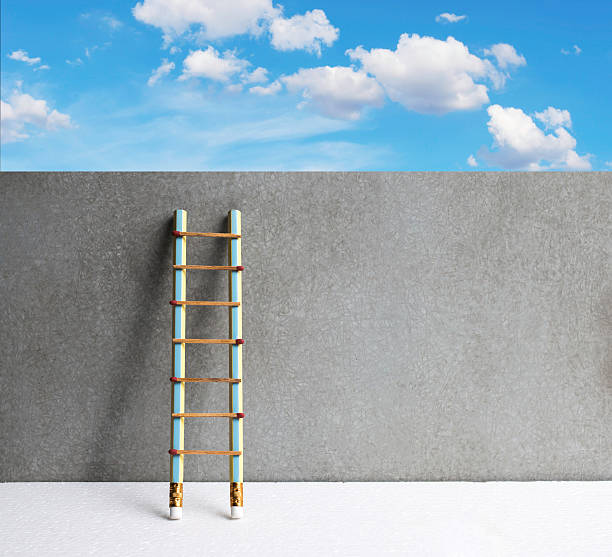 istock Pencil ladder leaning against grunge wall with copy space. succe 622064524