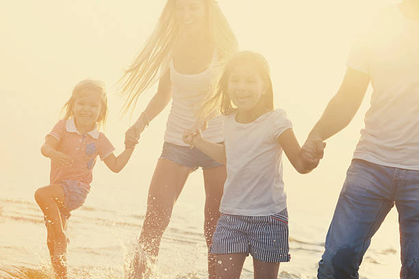 istock Family having fun runing on beach at sunset 622064892