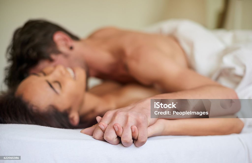 Connecting on every level Shot of an affectionate young couple making love in their bedroom in the morning Couple - Relationship Stock Photo
