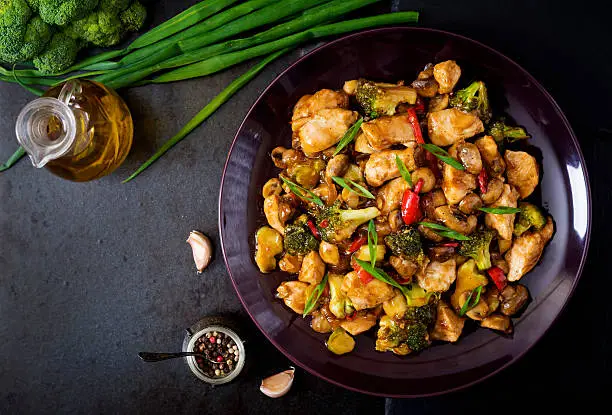 Stir fry with chicken, mushrooms, broccoli and peppers - Chinese food. Top view