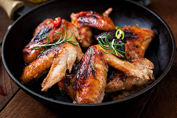 istock Baked chicken wings in pan on wooden table. 622068666