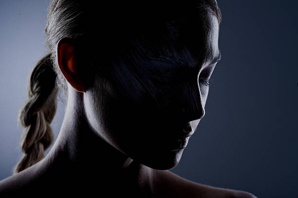 Studio shot of an attractive young woman posing against a dimly lit background