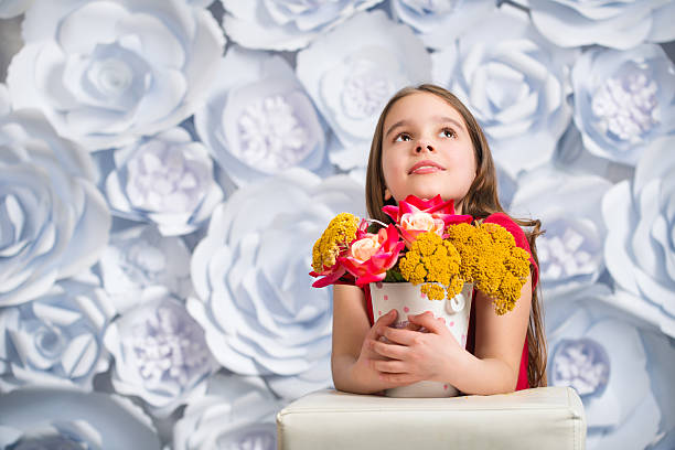 Adorable smiling little girl with artificial flower