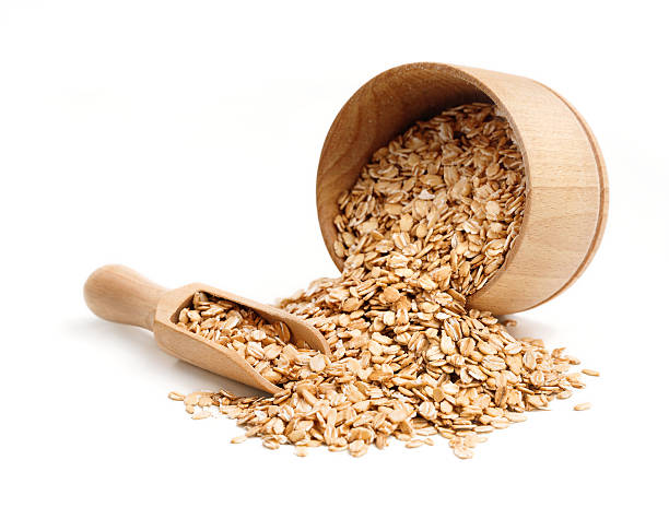 Oat flakes scattered from wooden bowl