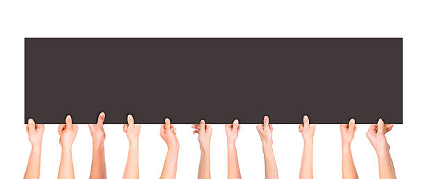 istock Many hands holding a blank dark poster for advertising 622071982