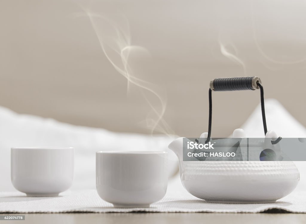 White teapot and cups on table at comfortable relaxation lounge Teapot and cups on table at comfortable relaxation lounge. Relaxation concept, pastel colours Bowl Stock Photo