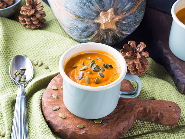istock Pumpkin soup with cream in green enamel mugs 622076520