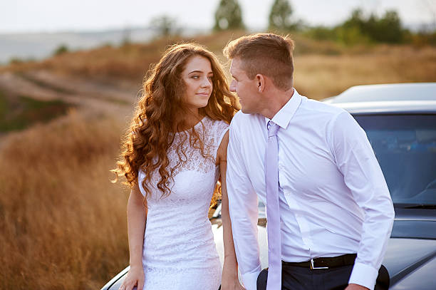 istock the bride and groom sit on the car in the 622077530
