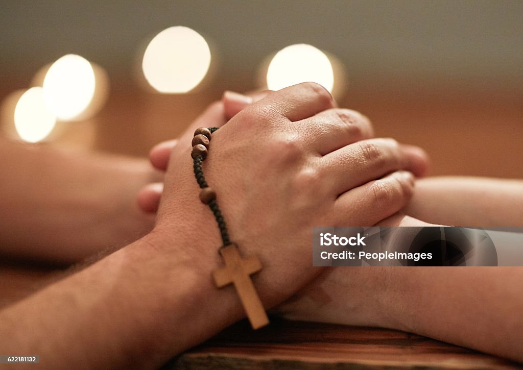 Hands are there to help others Cropped shot of two people holding hands and praying together Church Stock Photo