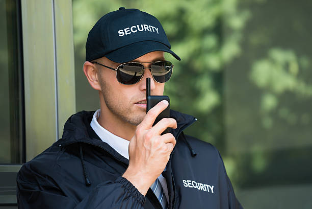 giovane guardia di sicurezza che parla a walkie-talkie - talkie foto e immagini stock