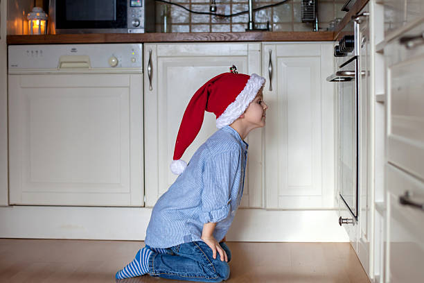 istock Curious little boy, watching ginger bread cookies in the oven 622184154