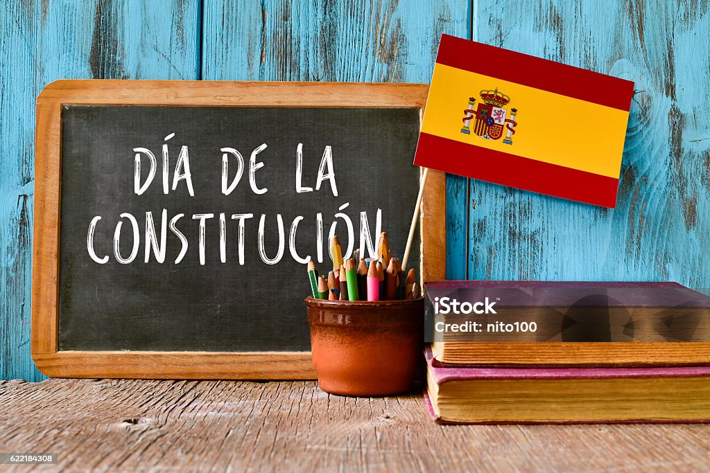 text constitution day written in spanish a chalkboard with the text dia de la constitucion, constitution day written in spanish, a pot with pencils, the flag of Spain and some old books, on a rustic wooden surface Spanish Constitution Stock Photo