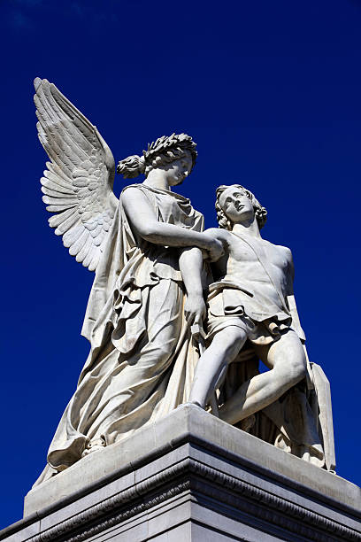 Berlin, Germany - December 9, 2019: The sculpture on the Schloss Bridge Schlossbruecke - Greek goddess Nike takes the fallen hero to Olympus. By August Wredow, 1857.