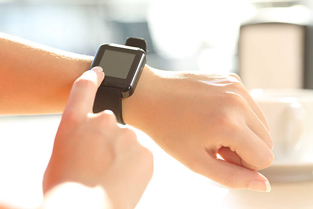 Woman hands using a smart watch in a bar