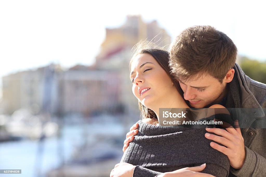Couple flirting with passion in the street Affectionate and passionate elegant couple seducing and flirting with passion with a coast urban background in winter Perfume Stock Photo