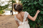 Bride peeking out from behind a tree