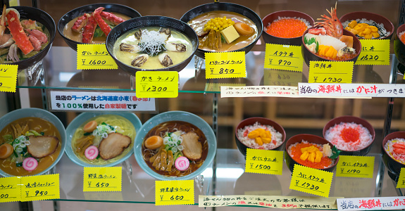 Food presented in Menu window, at entrance to the Fish market, which is currently offered. The food is plastic, bat it looks like the real one and each one has sign with its name and price. This is traditional way of presenting prepared food in japan.