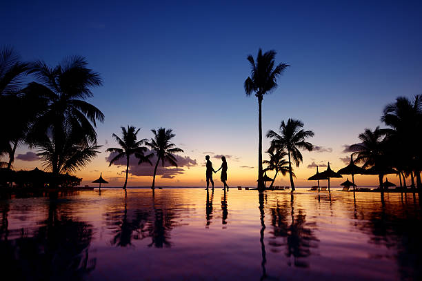 siluetas de pareja joven al atardecer escénico - honeymoon beach swimming pool couple fotografías e imágenes de stock