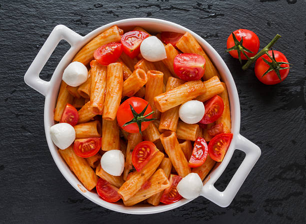penne pasta mit sauce, mozzarella-käse, tomaten, ansicht von oben - penne rigatoni pasta tomato pasta stock-fotos und bilder