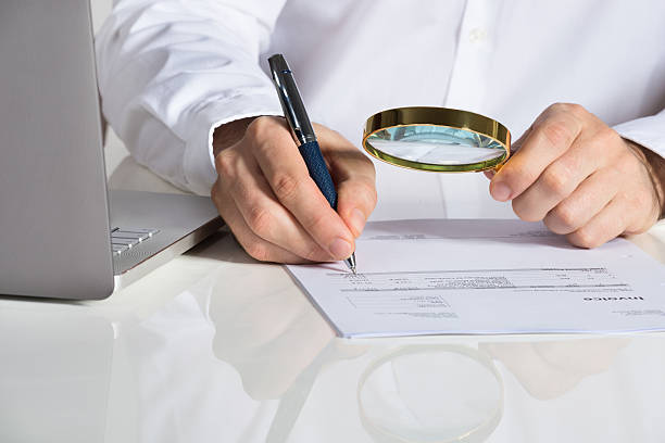 istock Businessman Analyzing Invoice With Magnifying Glass 622191374