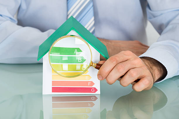 istock Businessman With House Model And Magnifying Glass 622191712