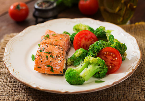 istock Baked fish salmon garnished with broccoli and tomato. 622191936