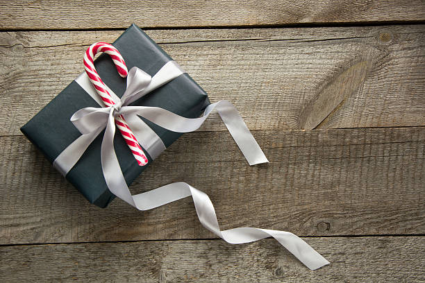 istock Christmas gift box in black paper with candy on board. 622193042