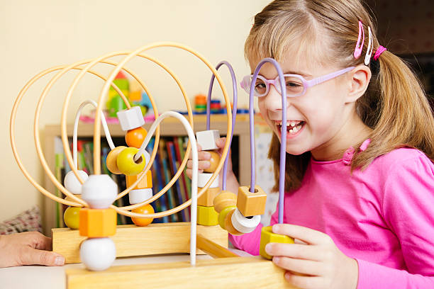istock Visually disabled child playing with wooden roller coaster bead toy 622193194