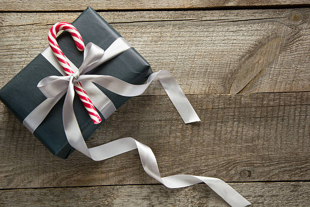 istock Christmas gift box in black paper with candy on board. 622193232